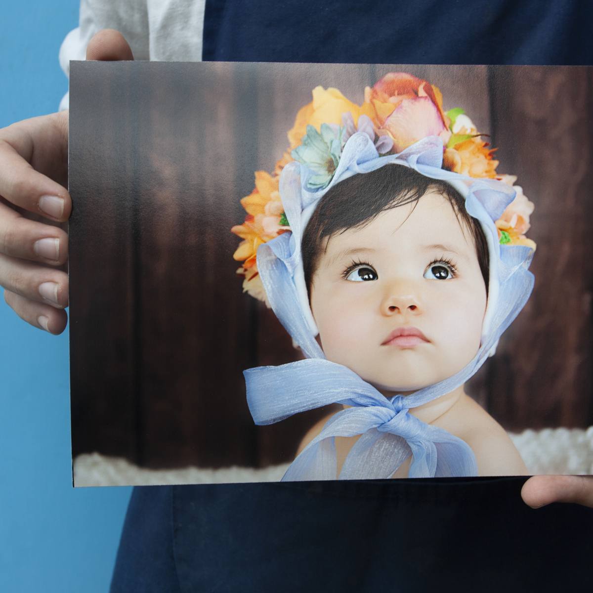 Lab staff hold and image of a baby printed on Ilford Gold Fibre Gloss