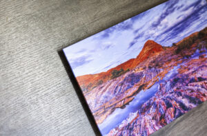Close up of the corner of an acrylic flush mount print of a mountain with vibrant colours