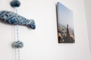 Photo of a girl looking over a lookout printed on a lustre photo wrap and hanging on a white wall next to wall ornament
