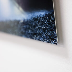 corner of an aluminium print or metal print floating slightly off the wall
