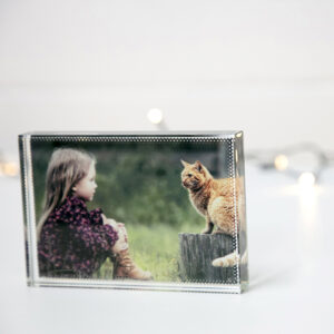 Glass photo block back lit by fairy lights with a printed image of a young girl and ginger cat