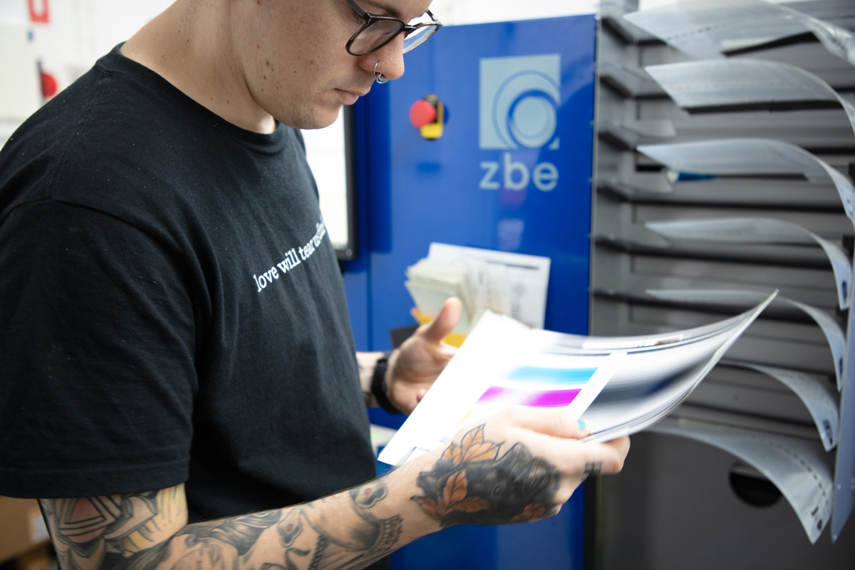 Man holds colour calibration print in front of ZBE printer