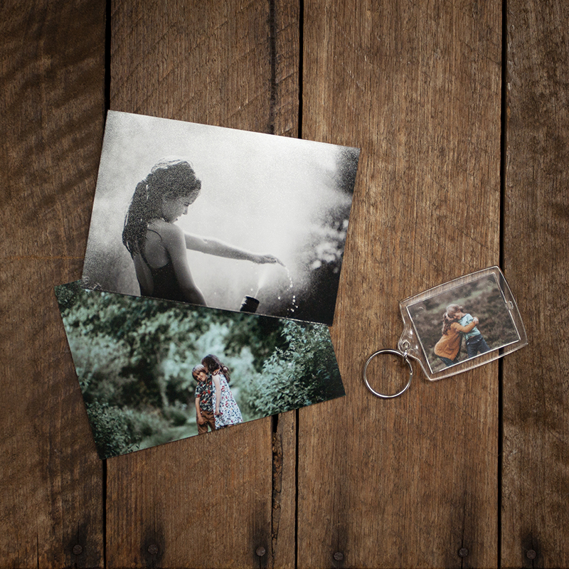 Two photo magnets and a photo keyring on a wooden box with images of a brother and sister
