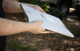 Young arms handing over a package outdoors