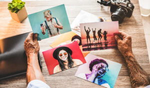 Hands holding colourful printed photographs