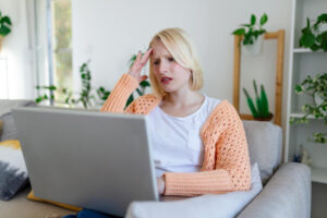 Confused looking woman sitting at a laptop